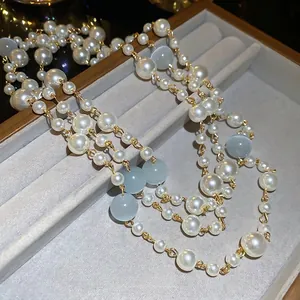 Collier multi-rangs de perles françaises et pierres œil de chat bleues sur plateau gris