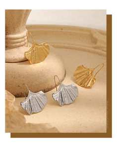 Détails des boucles d'oreilles feuille de ginkgo or et argent sur socle pierre