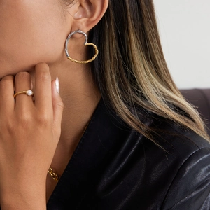 Minimalist 18K gold and silver two-tone hammered heart hoop earrings on model