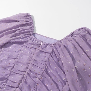 Dettaglio dello scollo quadrato e dell'abito in chiffon lavanda a pieghe con stampa floreale