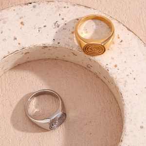 Detailed top view of 18K gold and silver rings with fingerprint spiral pattern on stone