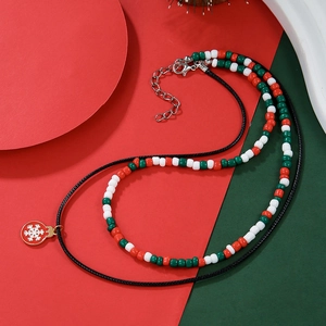 Detail view of a beaded Christmas necklace with a snowflake pendant on festive props