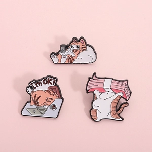 Enamel orange cat brooch set with three funny scenes on a pink background