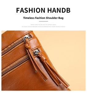Detail showing brown leather texture and multi-layer zipper with tassel pulls