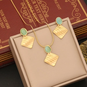 Irregular geometric jewelry set with green oval gemstones on a textured gold necklace