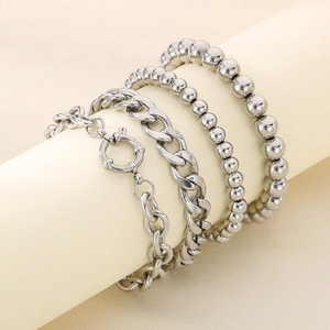 Close-up of four-piece silver stackable bracelet set with cuban and bead chains