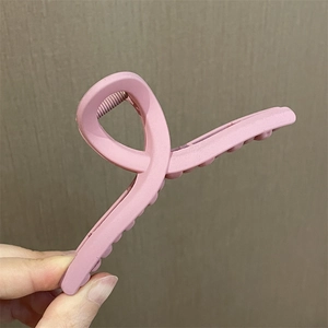 Detalle de la pinza para el pelo rosa mate con elegante diseño retorcido y textura suave