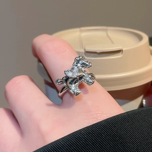 Macro shot of silver poodle ring with heart-shaped zircon and pave crystals on finger