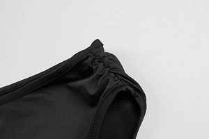 Macro detail of side ruched design and precise stitching on black sleeveless dress