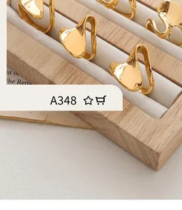Détail macro de boucles d'oreilles dorées en forme de C au design fluide géométrique