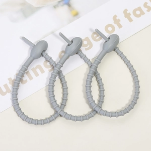 Three grey flexible silicone cable ties with adjustable holes for cable organization