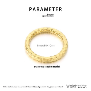 Macro detail of golden stainless steel bangle with geometric rhombus pattern and glossy finish