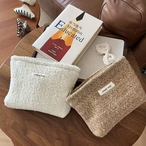 Detail of tweed makeup pouches with simple wish label on a wooden table setup