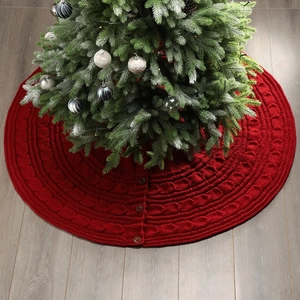 Classic red cable knit Christmas tree skirt with wooden buttons on light wood floor