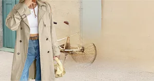 Detail of classic beige double-breasted trench coat with adjustable cuffs and waist belt