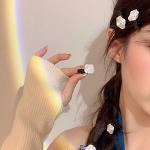 Dettagli di graziose mollette a fiori bianchi 3D indossate con una clip a becco d'anatra