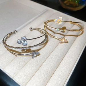 Detailed macro view of multi-layered floral bangles with micro-pave diamonds and pearls