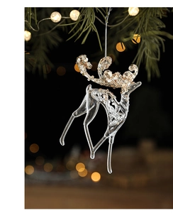 Macro view of transparent acrylic reindeer ornament with golden glitter on Christmas tree