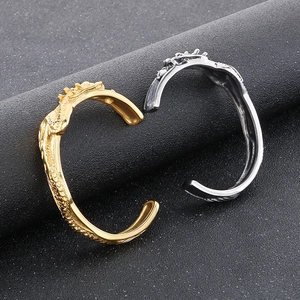 Dettaglio dei bracciali vintage a drago in oro e argento con trame di squame fini