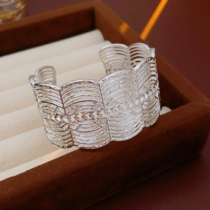 Detailansicht der silbernen offenen Manschette mit hohlem Wellenmuster in Schmuckbox