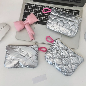 Detail of silver quilted pouches featuring heart and diamond patterns with pink lanyards