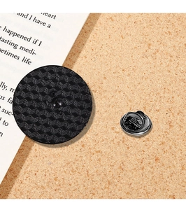Detailed back view of a black metal ant brooch with textured finish and secure clutch