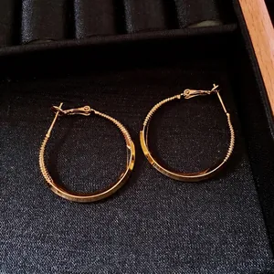 18k gold plated round hoop earrings with smooth and spiral texture in jewelry box