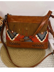 Detail of bohemian crossbody bag with tribal patterns and brown faux leather fringe