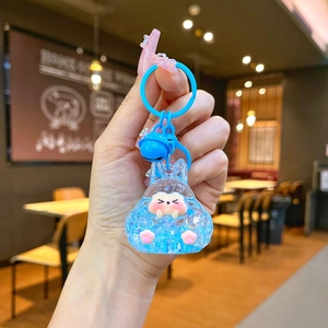 Blue resin rabbit keychain with a pink animal charm and matching bell ornament
