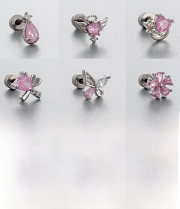 Détail macro de boucles d'oreilles en zircon rose en forme de cœur et fleur en acier