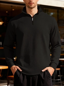 Detailed view of black waffle texture fabric on men's quarter-zip sweatshirt collar