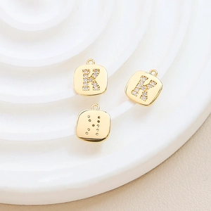 Macro view of gold-plated square letter K pendants with inlaid cubic zirconia crystals