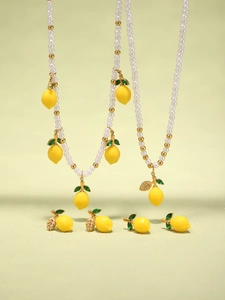 Dettaglio dei ciondoli a limone in resina e perle lucide su questo set di gioielli