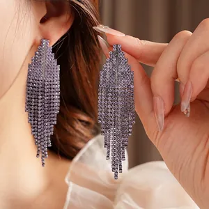 Elegant geometric drop earrings featuring purple crystals and long flowing tassel fringe