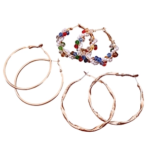 Three pairs of vintage gold hoop earrings with smooth metal, colorful beads, and textured finish