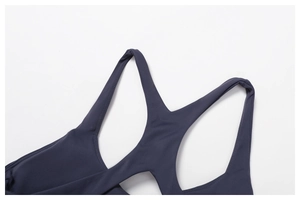Détail du haut de yoga gris foncé montrant les coutures doubles et les bretelles croisées