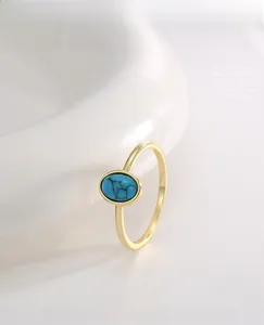 Macro shot of a vintage gold ring featuring a blue turquoise stone on white ceramic