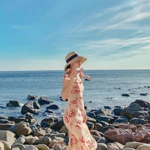 Bohemian off-white sun hat with black ribbon and floral dress for summer beach vacation