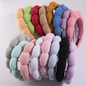 Macro shot of colorful terry cloth headbands stored in a white metal basket
