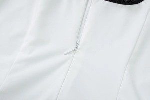 Détail d'une fermeture éclair invisible blanche avec dentelle noire sur une robe courte
