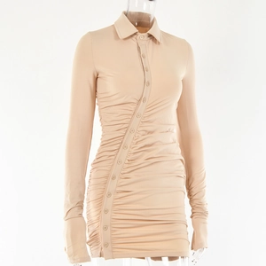 Détail d'une robe abricot à manches longues avec boutons asymétriques et plis drapés