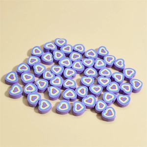 Détail de perles en argile violettes en forme de cœur avec motifs concentriques pour DIY
