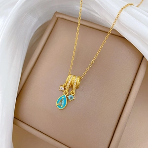 Close-up of golden tassel necklace with blue enamel pendant and sparkling zircons