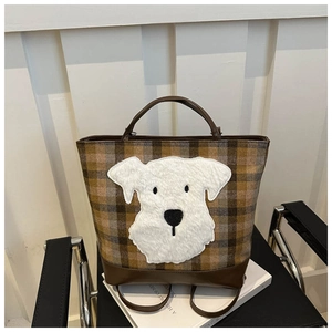 Detail of checkered tote bag with a white fuzzy cartoon dog patch and dual handles