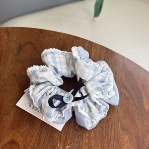 Blue plaid oversized hair scrunchie with lace edge and ribbon on a wooden table