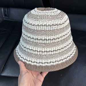 Close-up of hollow knit texture on beige and brown striped crochet bucket hat