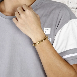 Détail d'un bracelet pour homme en acier inoxydable doré avec chaîne tressée à double rangée