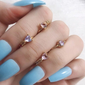Vue détaillée de quatre piercings de nombril en forme de cœur avec cristaux colorés