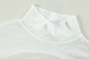Détail d'une robe blanche à col montant montrant le mesh et la maille fine