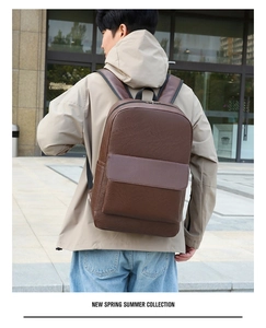 Deep brown leather business backpack with lychee texture shown on male model outdoors